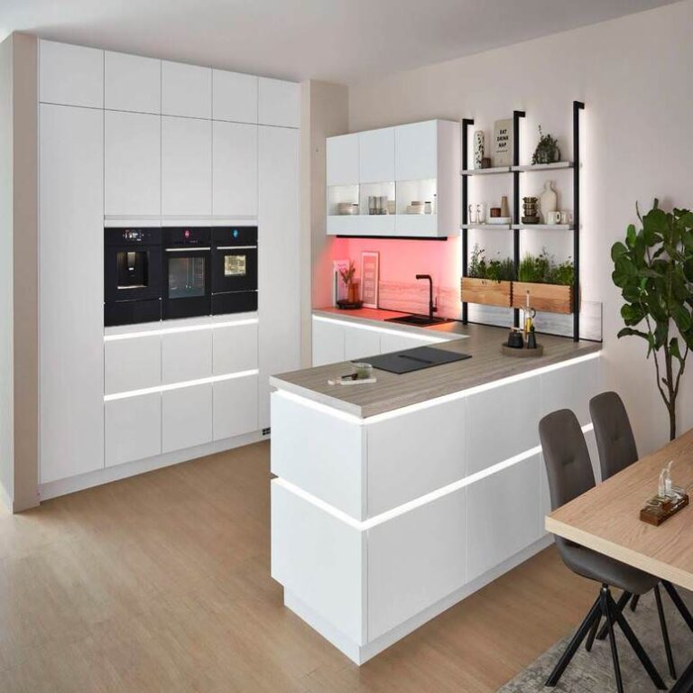 Moderne grifflose Küche in Weiß mit beleuchteter Kochinsel und Kräuterregal – Küchenstudio Heidelberg
